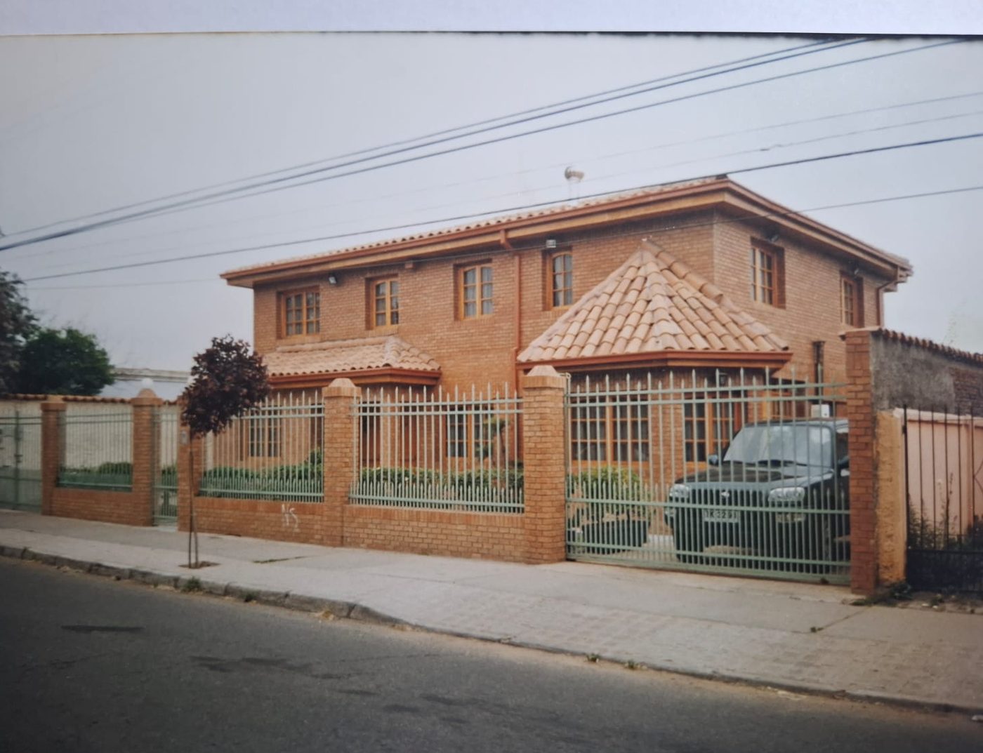 Vivienda de un piso con teja colonial y acceso enrejado